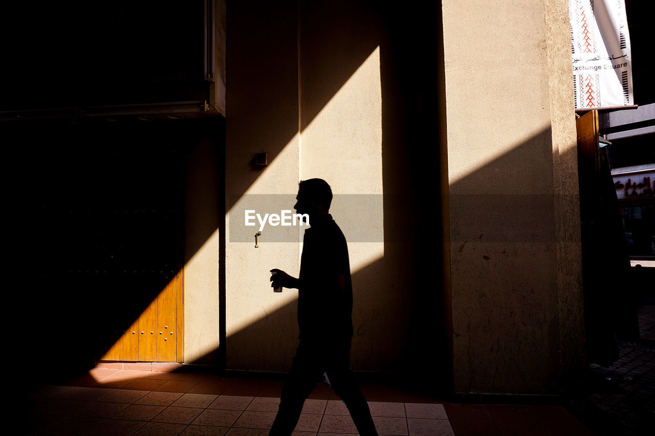 SIDE VIEW OF MAN WALKING IN BUILDING