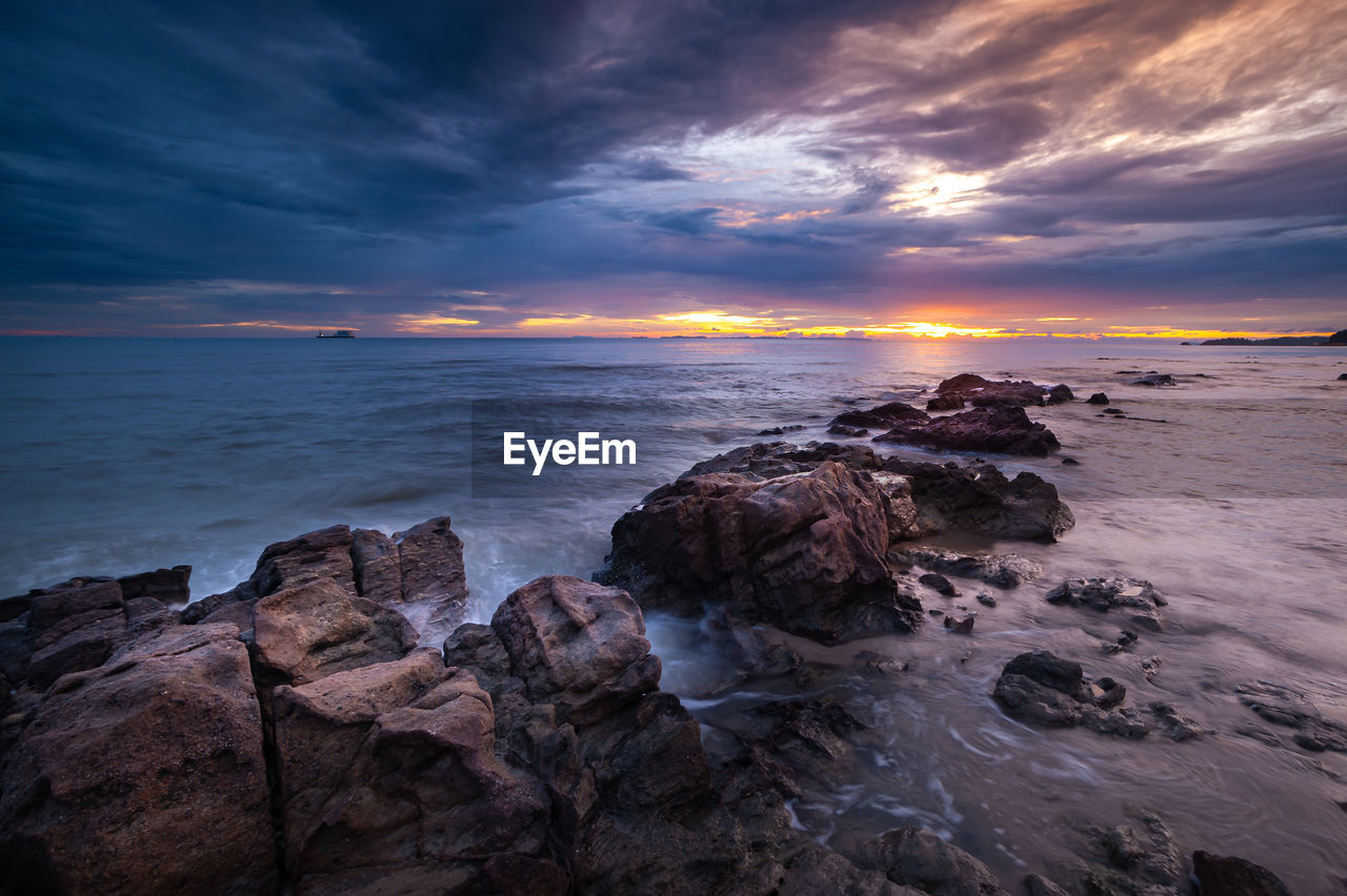 scenic view of beach against sky during sunset