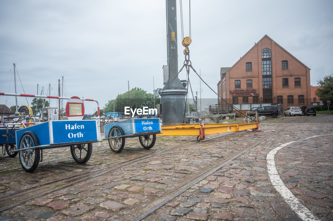 transport, architecture, transportation, mode of transportation, city, street, built structure, building exterior, sky, vehicle, building, cloud, road, day, land vehicle, nature, no people, urban area, motor vehicle, outdoors, car, city street, city life