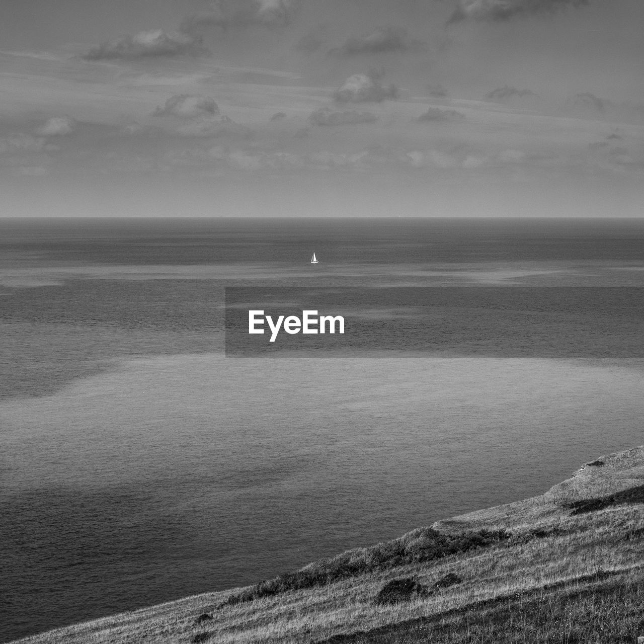 Scenic view of sea against sky with sailboat.