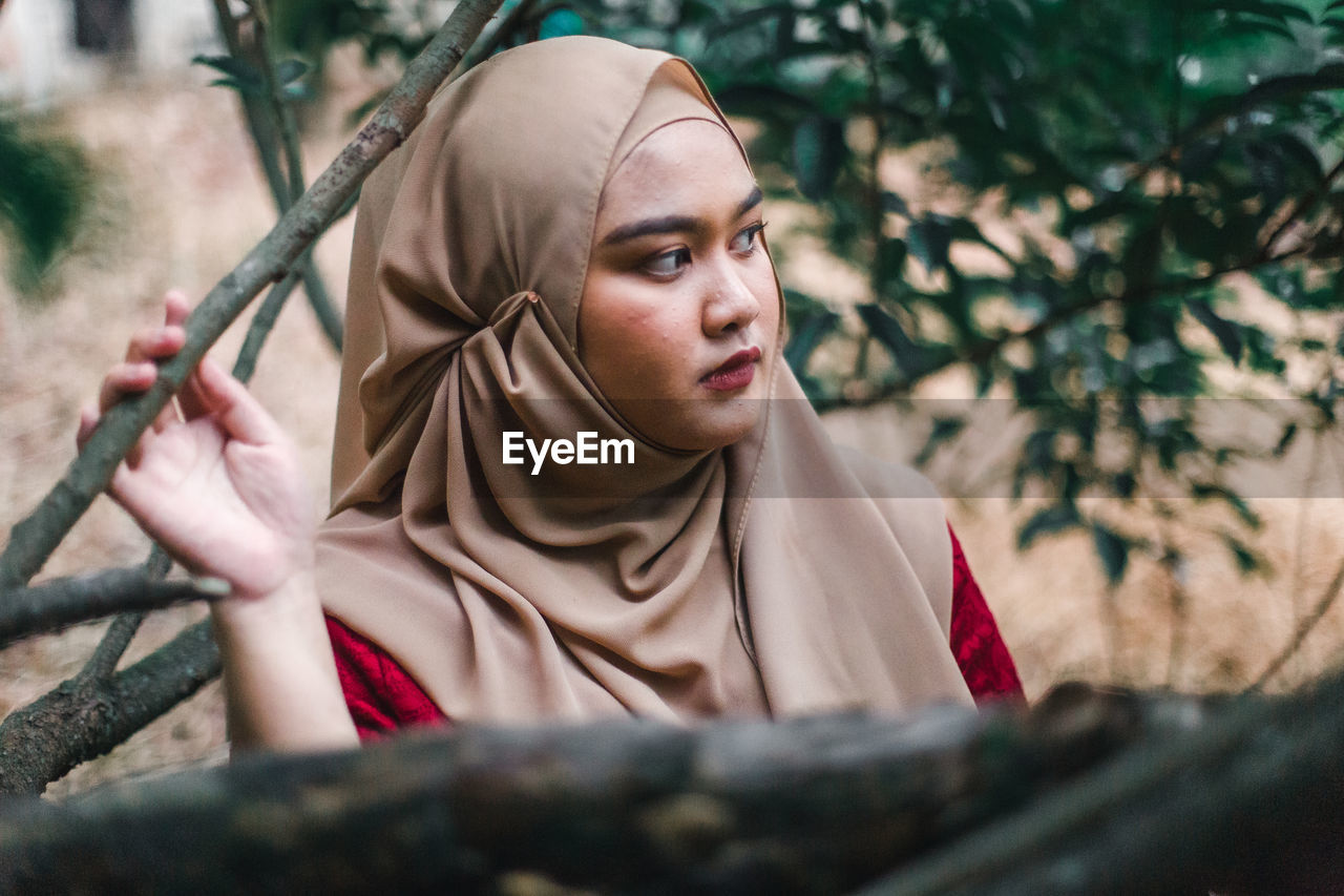 Thoughtful young woman wearing hijab looking away