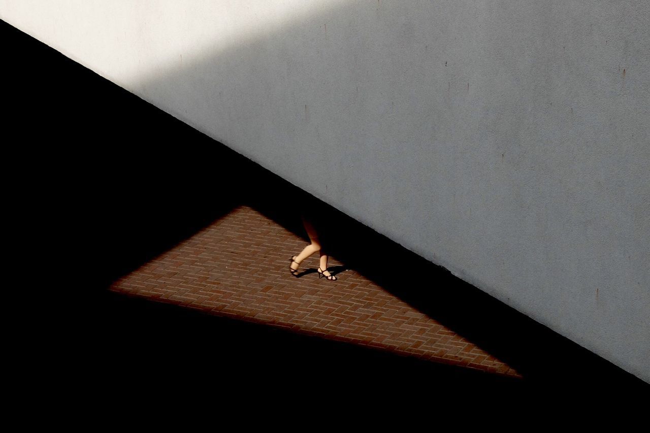 Low section of woman walking under bridge