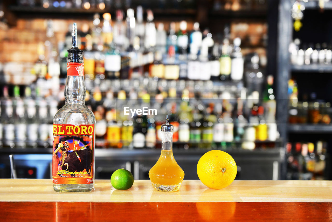 DEFOCUSED IMAGE OF ILLUMINATED BOTTLES ON BAR