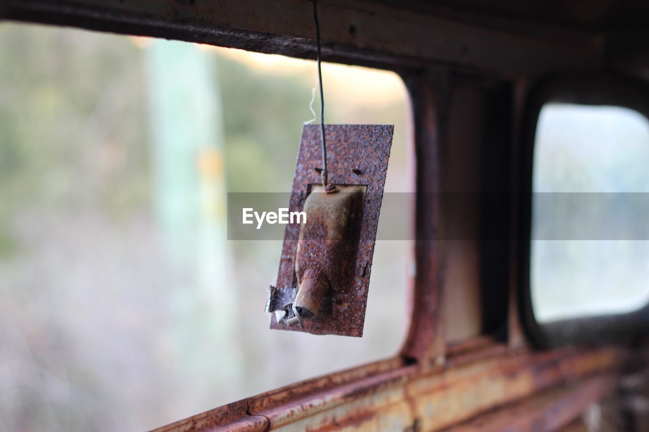 CLOSE-UP OF OLD RUSTY HANGING FROM WINDOW