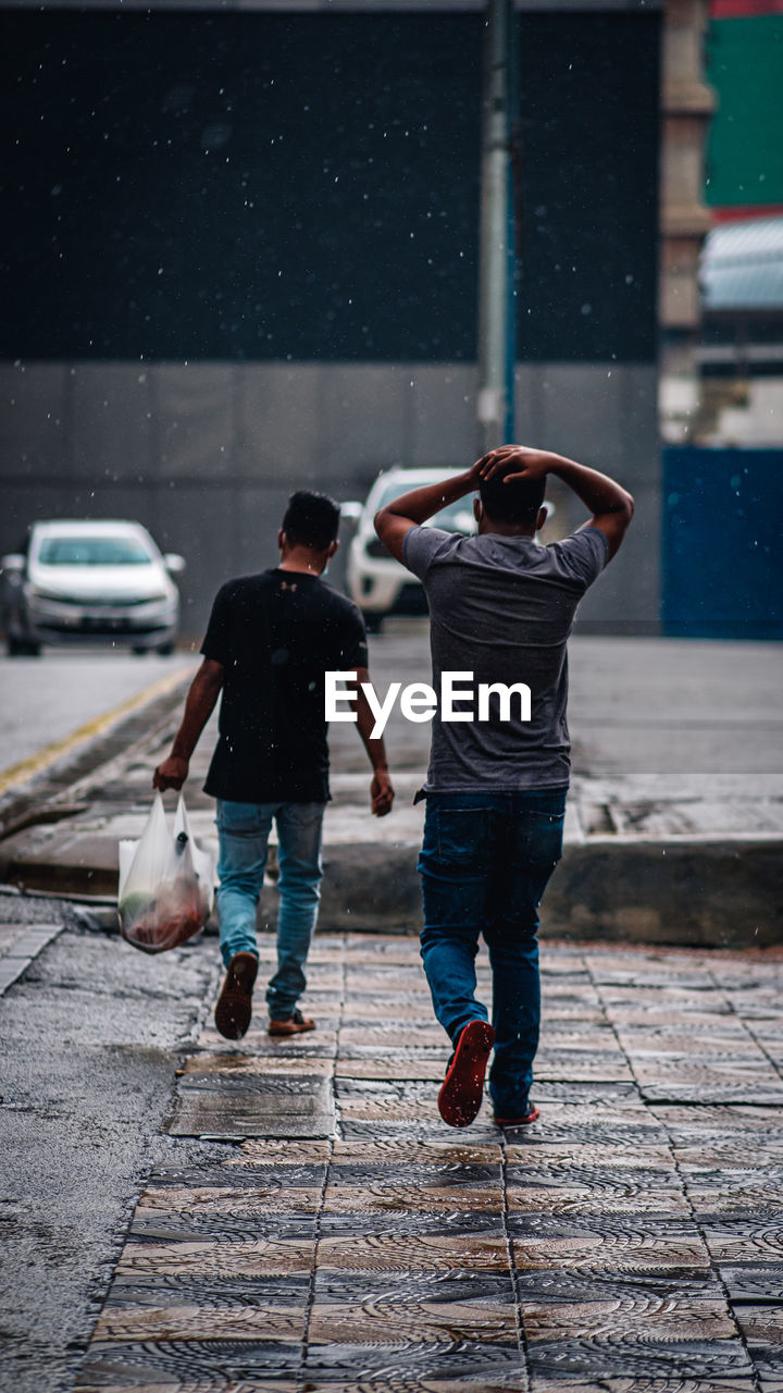 FULL LENGTH REAR VIEW OF PEOPLE WALKING ON STREET