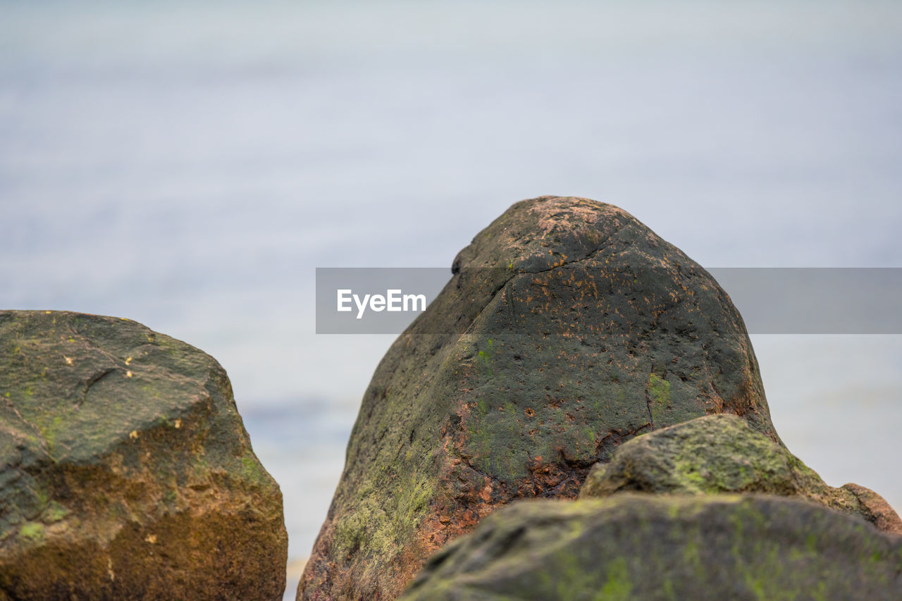 CLOSE-UP OF ROCK AGAINST SEA