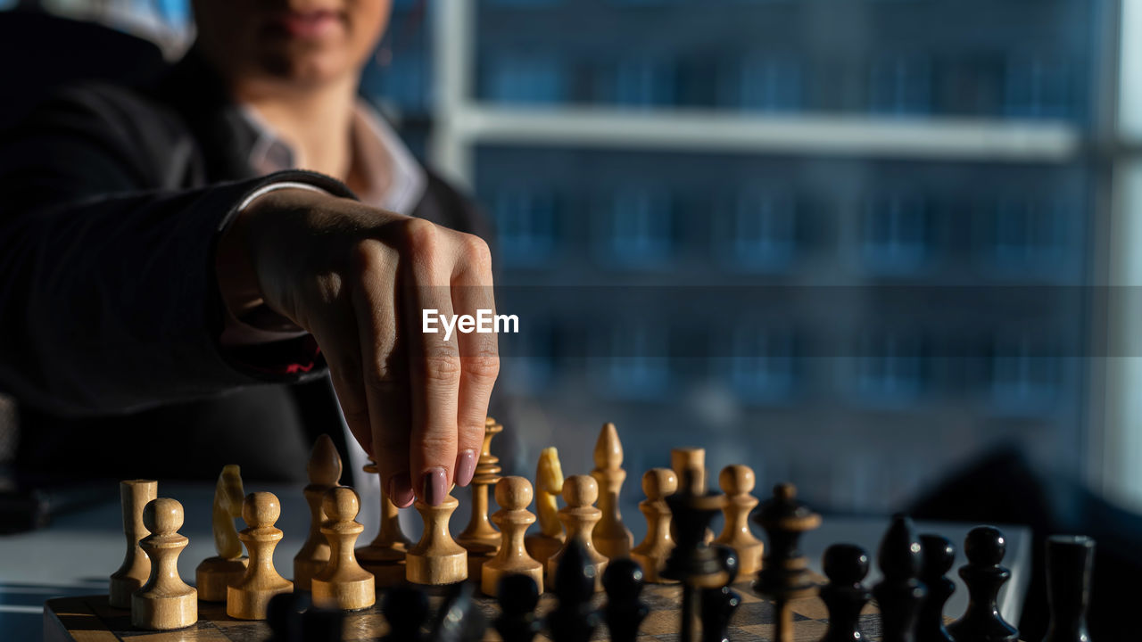 Midsection of man playing on chess board