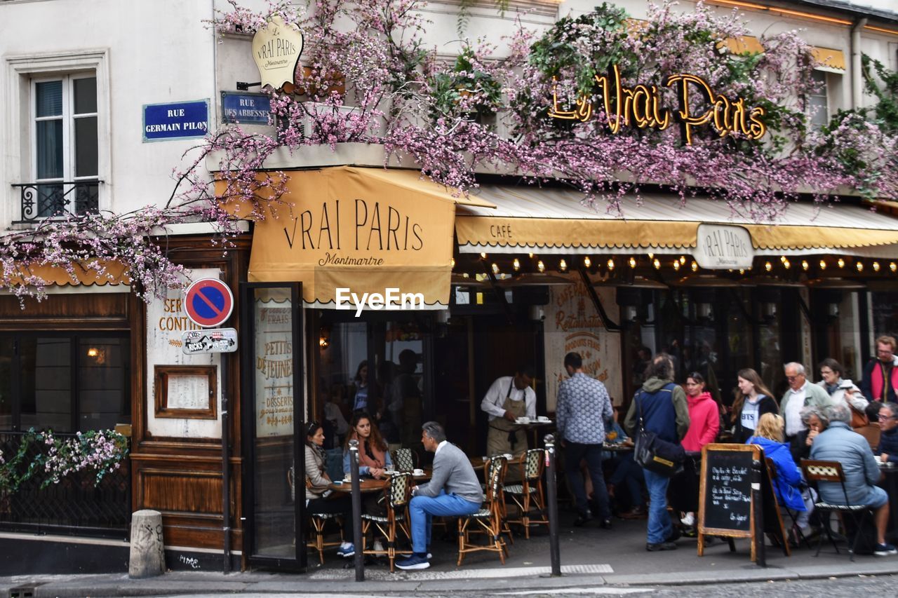 GROUP OF PEOPLE IN RESTAURANT AGAINST BUILDINGS