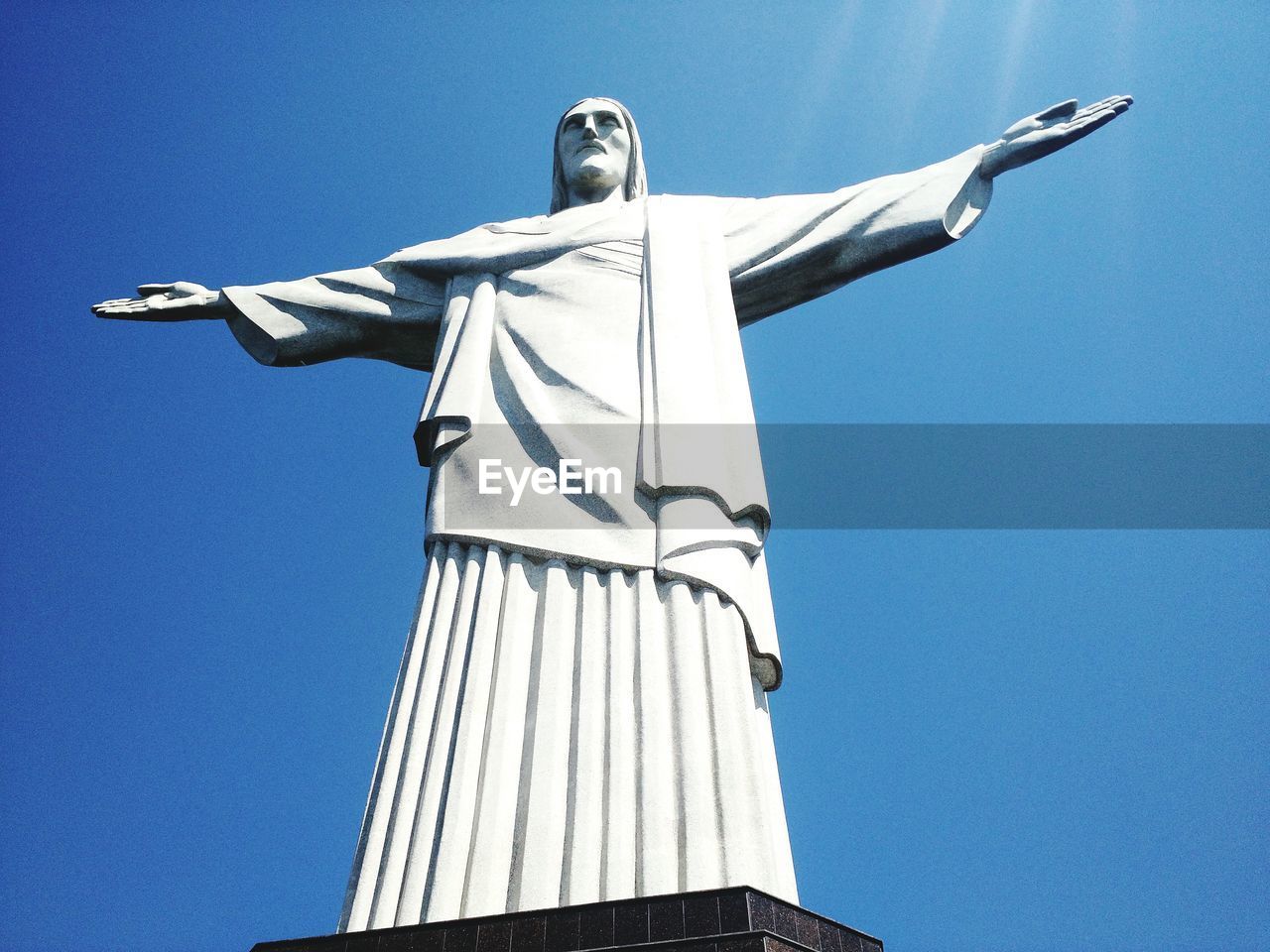 Low angle view of christ the redeemer statue against blue sky