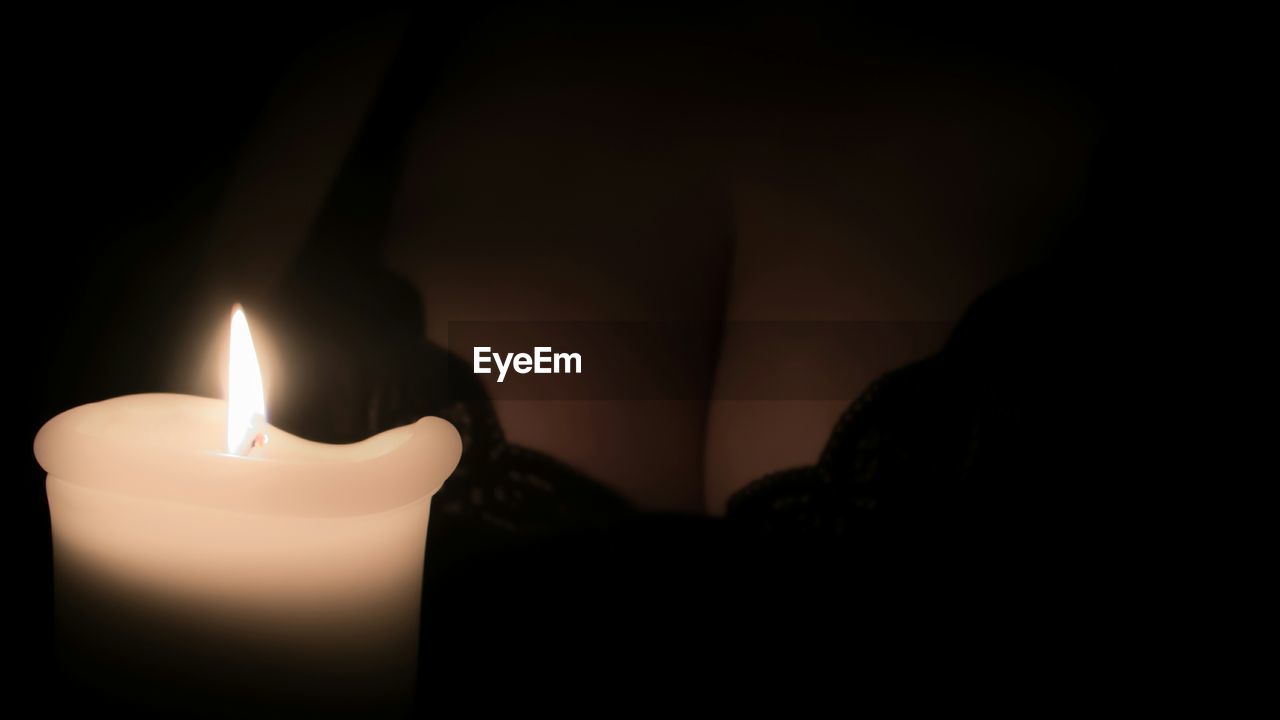 Close-up of woman holding candle in darkroom