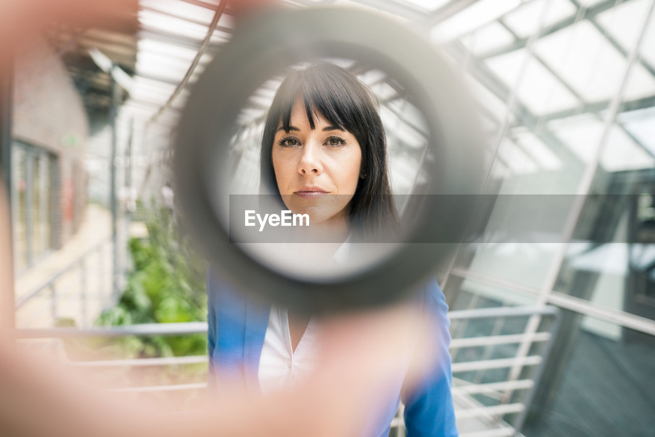 Businesswoman seen through equipment in office corridor