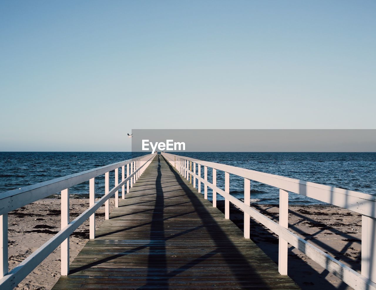 Pier on sea against clear sky