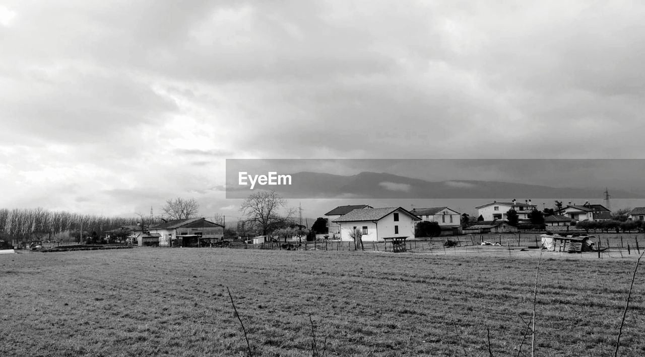Houses on field against sky