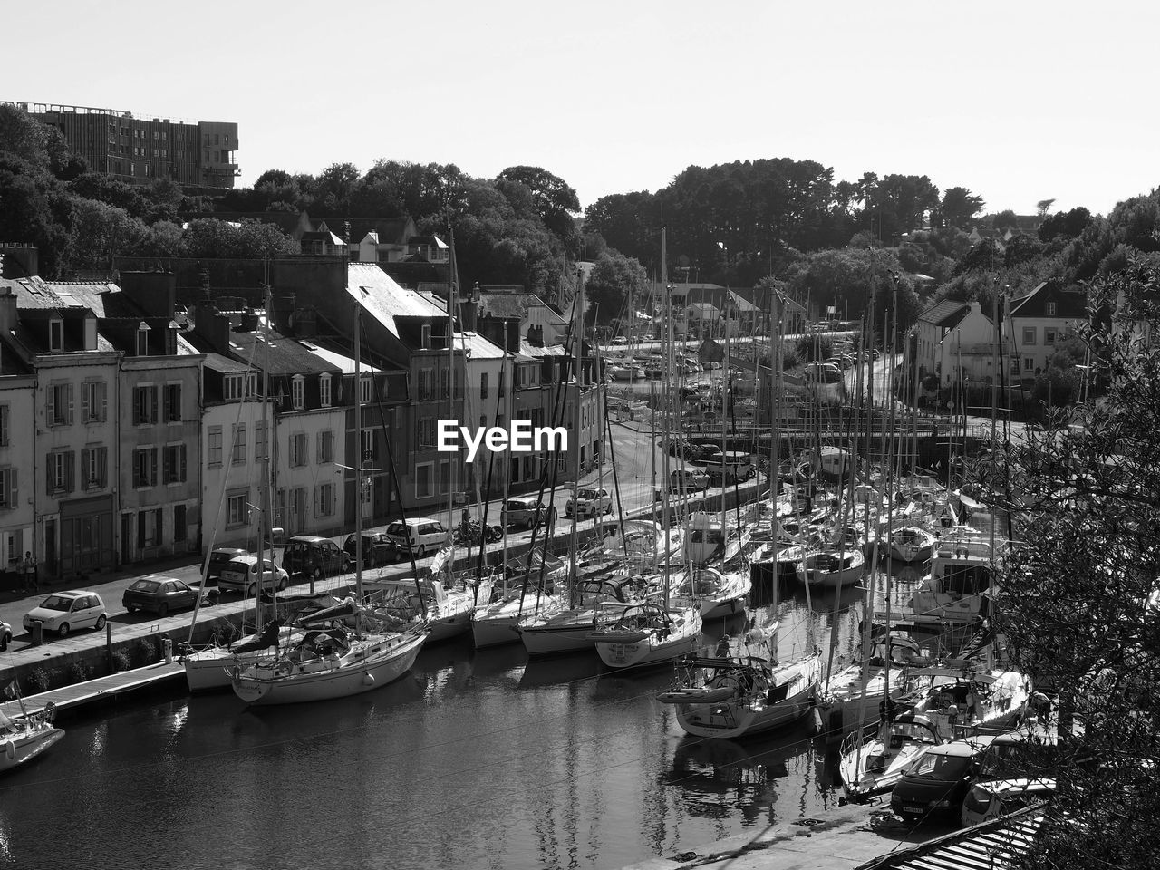 BOATS IN RIVER BY BUILDINGS AGAINST SKY