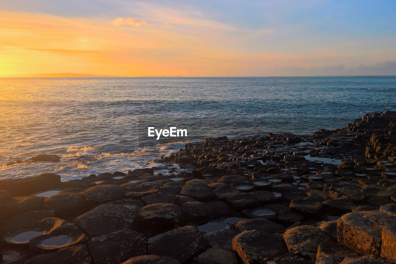 Scenic view of sea against sky during sunset at giants causeway