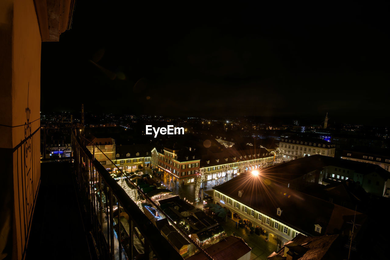 HIGH ANGLE VIEW OF ILLUMINATED BUILDINGS AGAINST SKY AT NIGHT