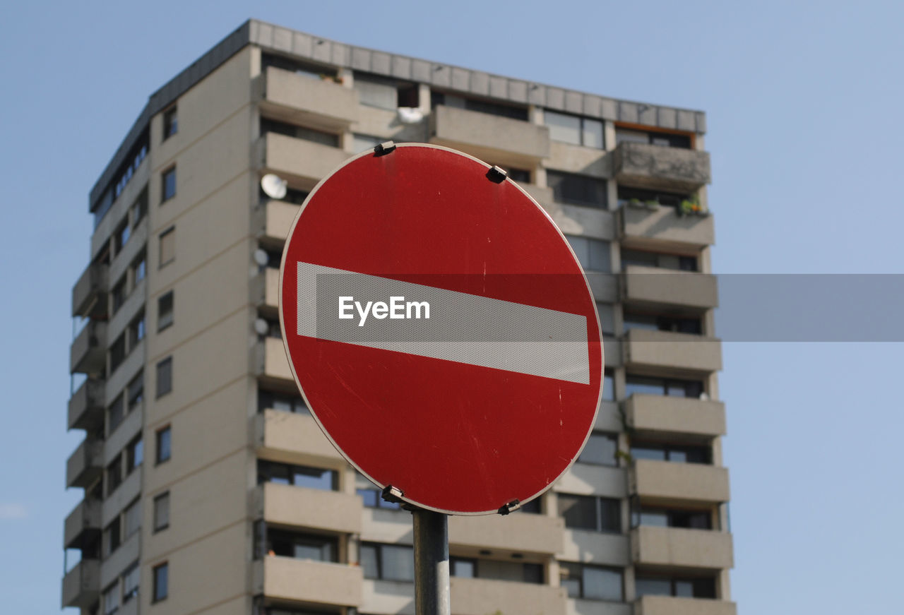 Skyscraper in the city, with a no entry traffic sign in front of it