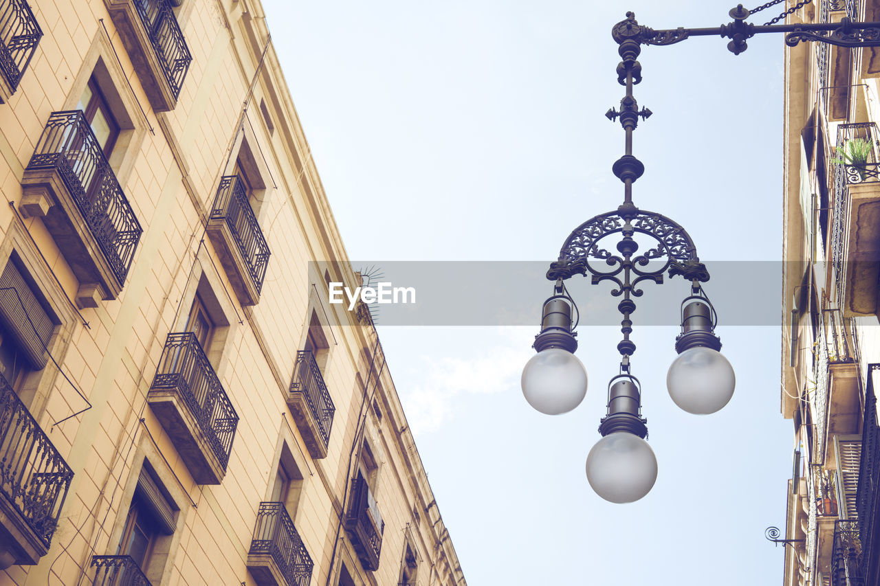 LOW ANGLE VIEW OF STREET LIGHT AGAINST BUILDINGS