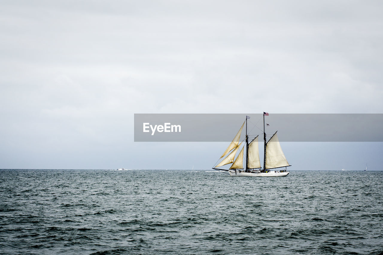 Sailboat in sea against sky