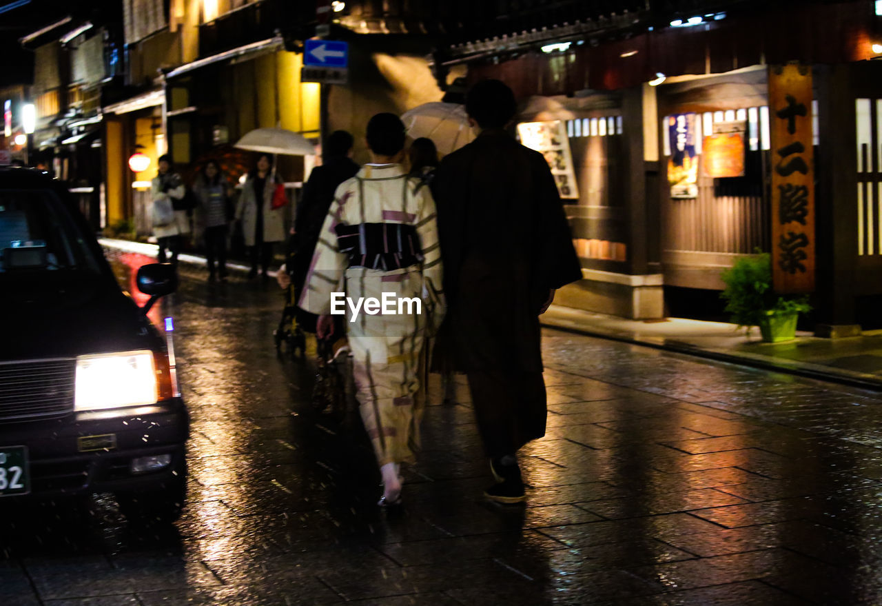 REAR VIEW OF TWO MEN IN CITY