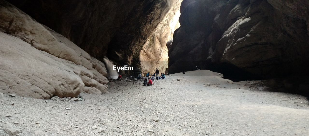 REAR VIEW OF PEOPLE ON ROCK FORMATION
