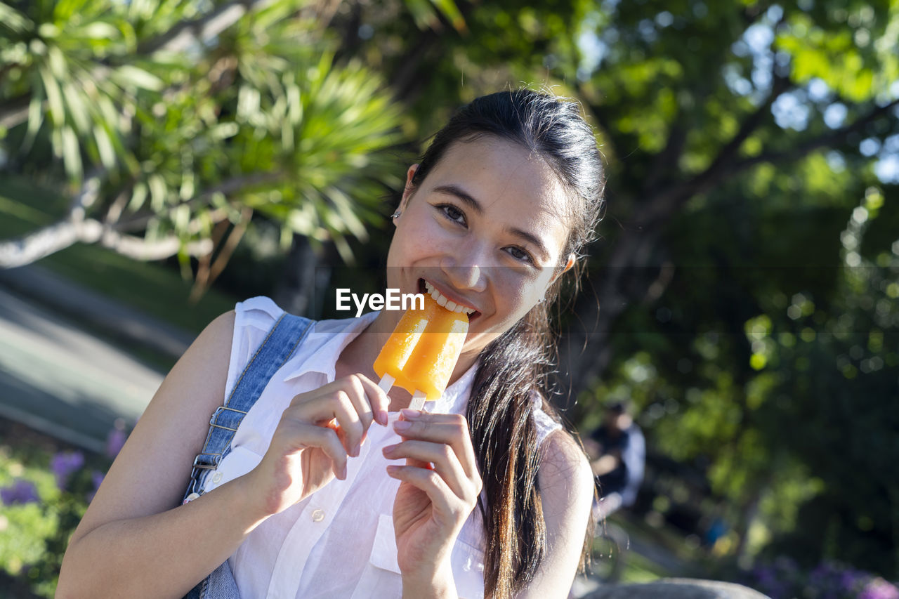 Portrait of young woman holding ice cream.