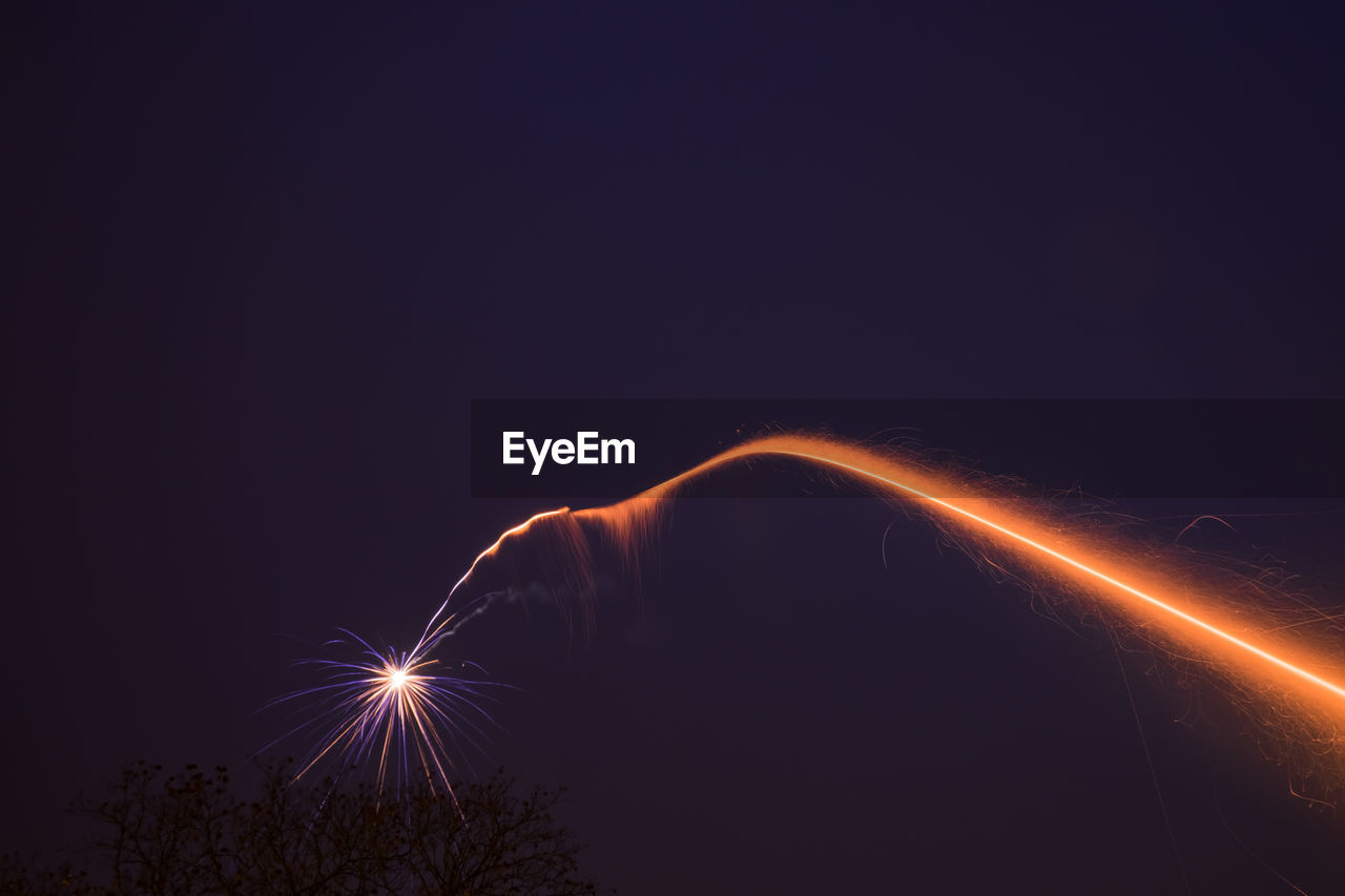 Low angle view of illuminated fireworks against sky at night