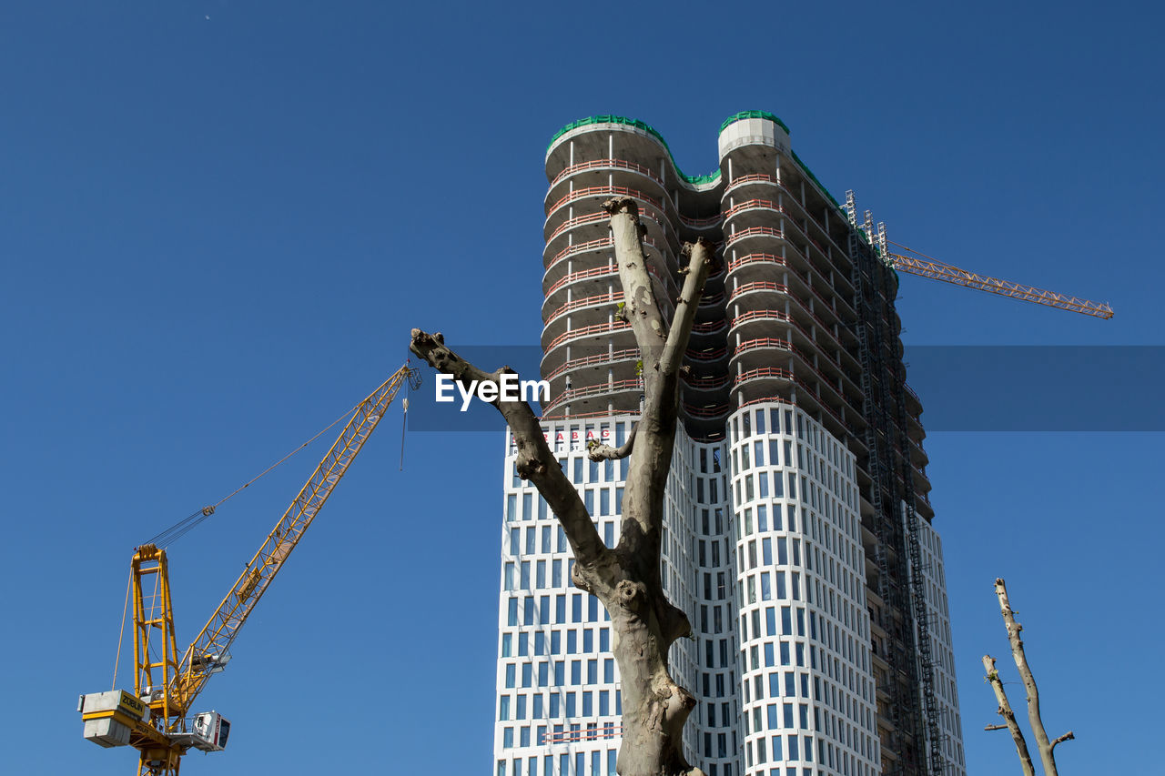 Low angle view of under construction building against clear blue sky