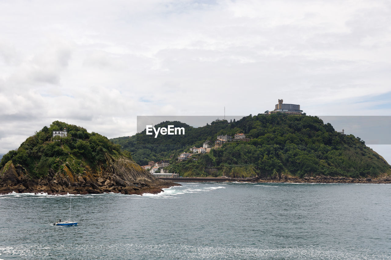 Scenic view of sea by building against sky