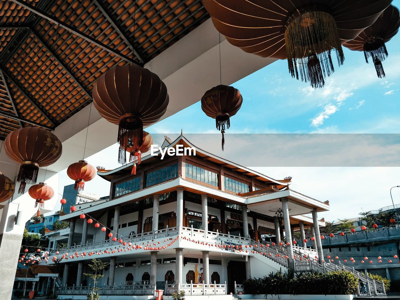 Low angle view of lanterns hanging from building against sky