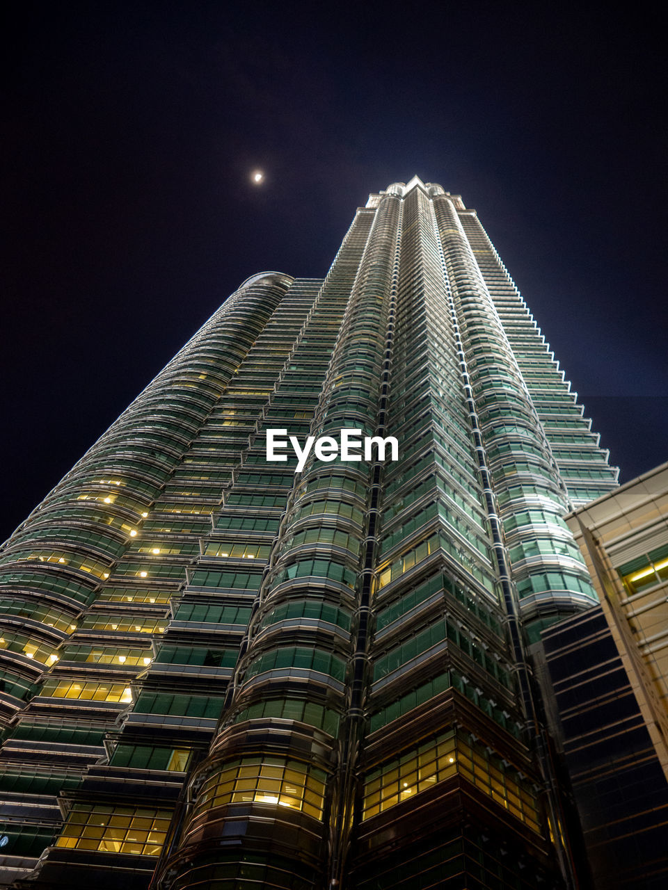 Low angle view of illuminated buildings against sky at night