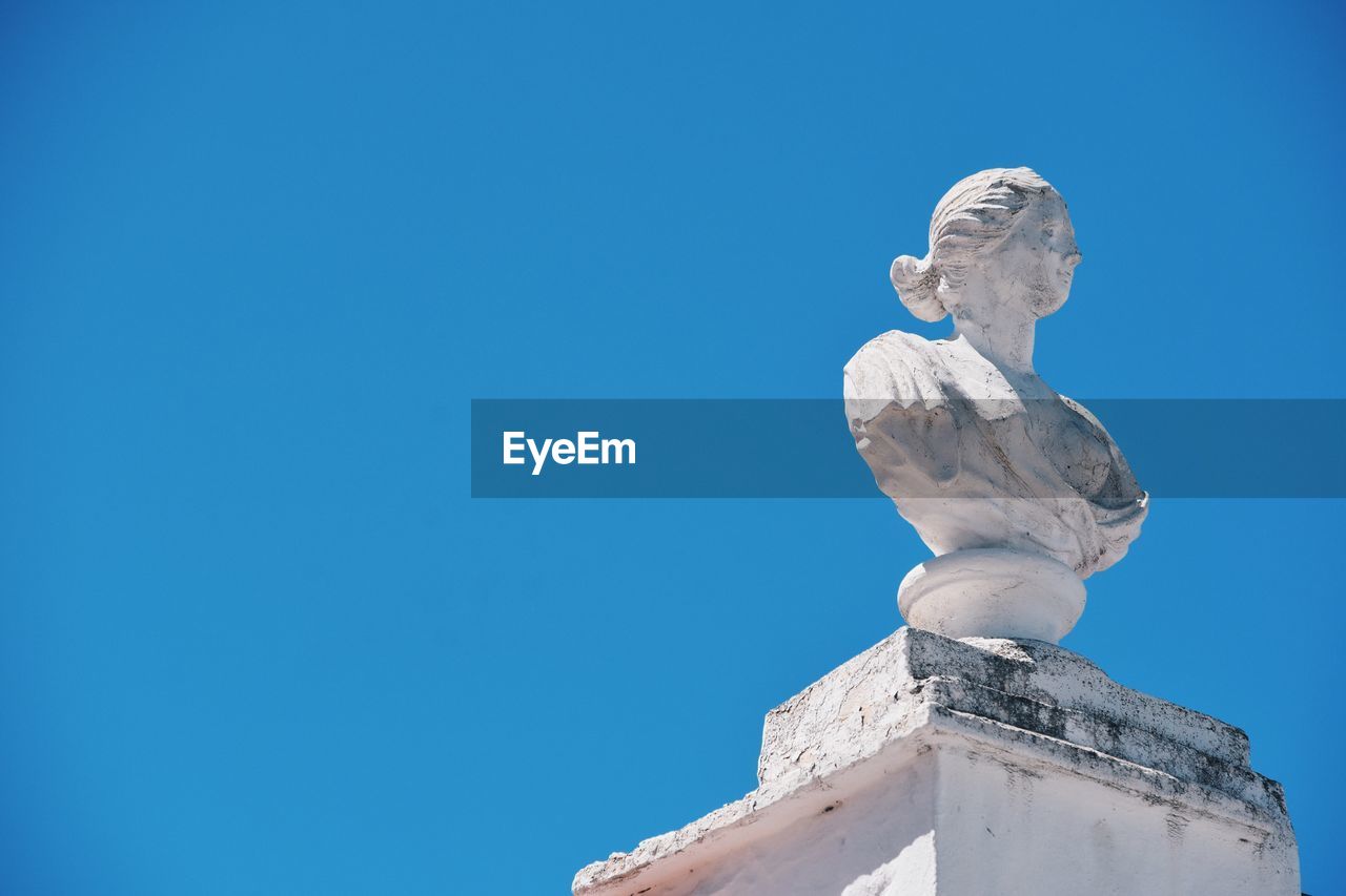 Low angle view of statue on column against clear sky