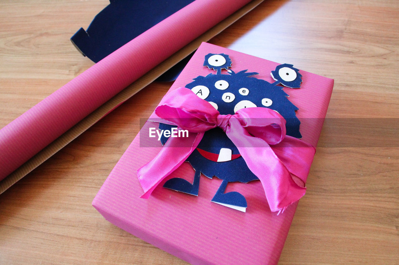 Close-up of pink tied bow on book at table