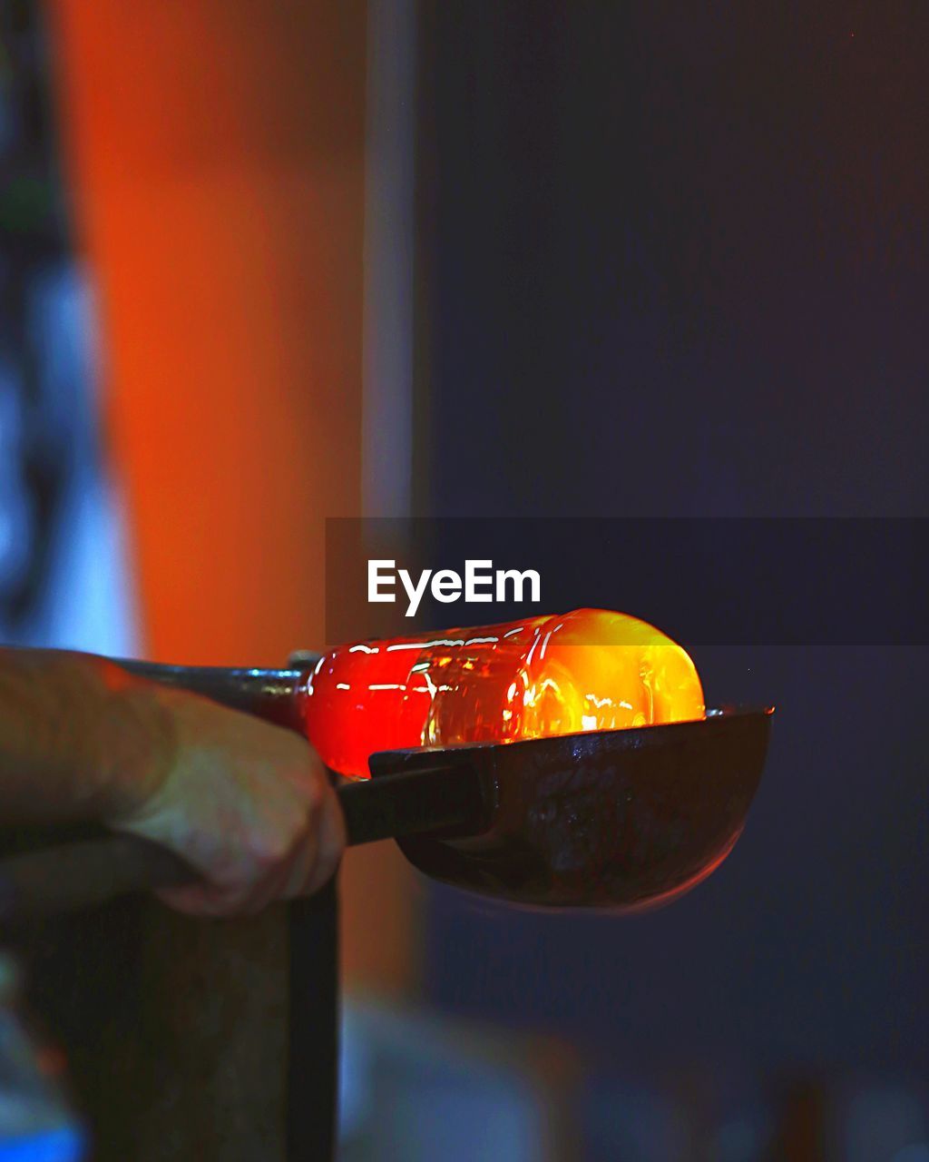 Cropped hand of worker making glass in factory