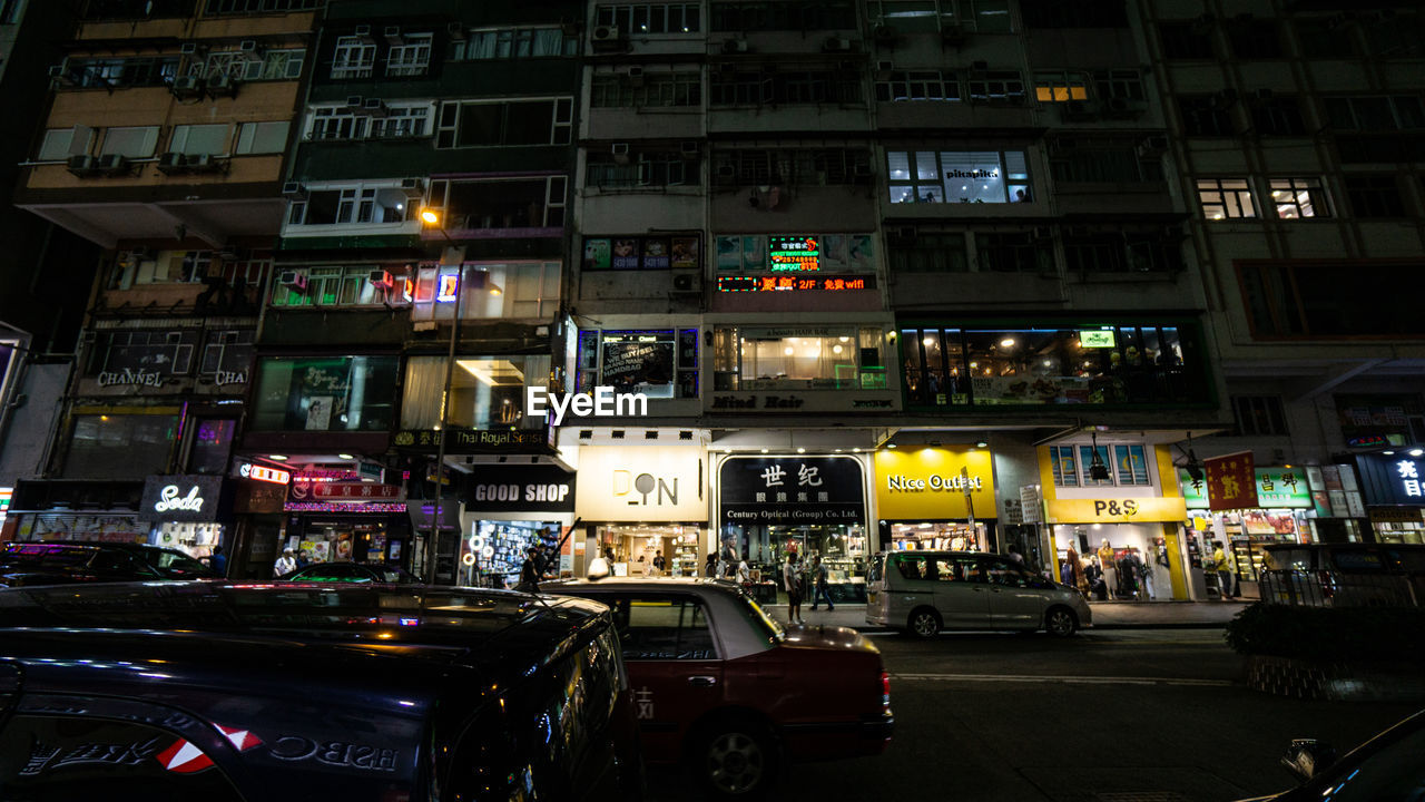 VEHICLES ON ROAD IN CITY AT NIGHT