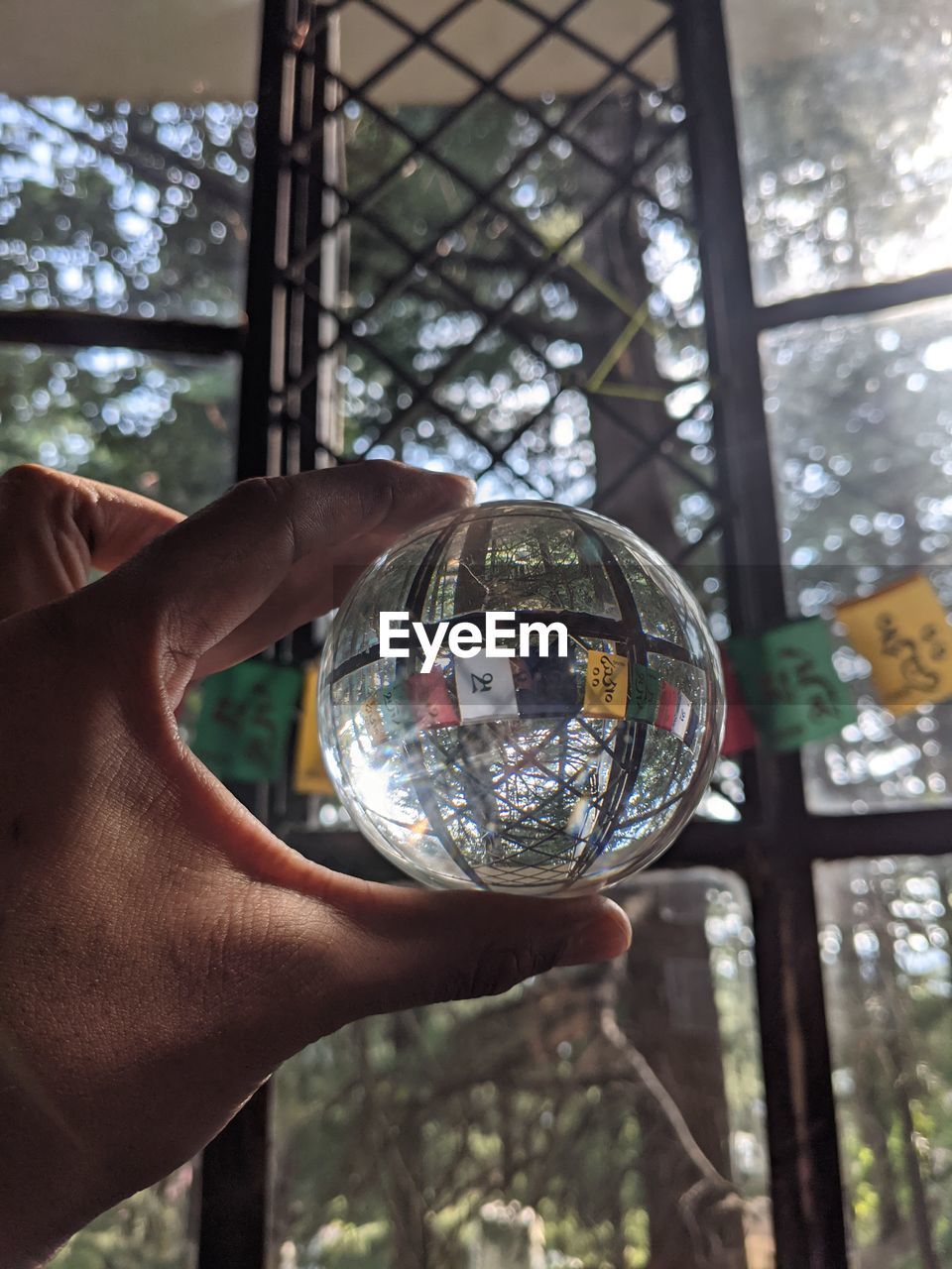 CLOSE-UP OF HAND HOLDING GLASS WITH REFLECTION