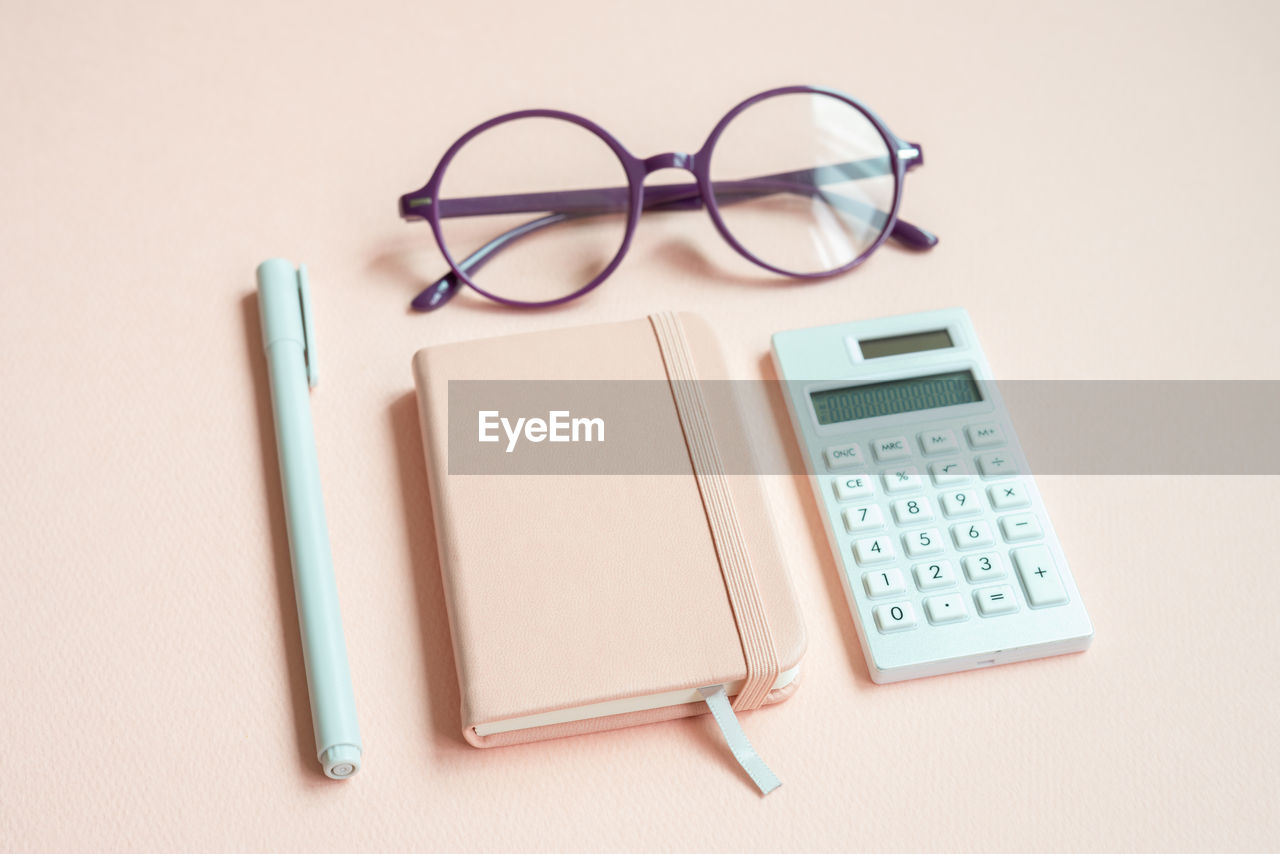 high angle view of calculator and eyeglasses on table