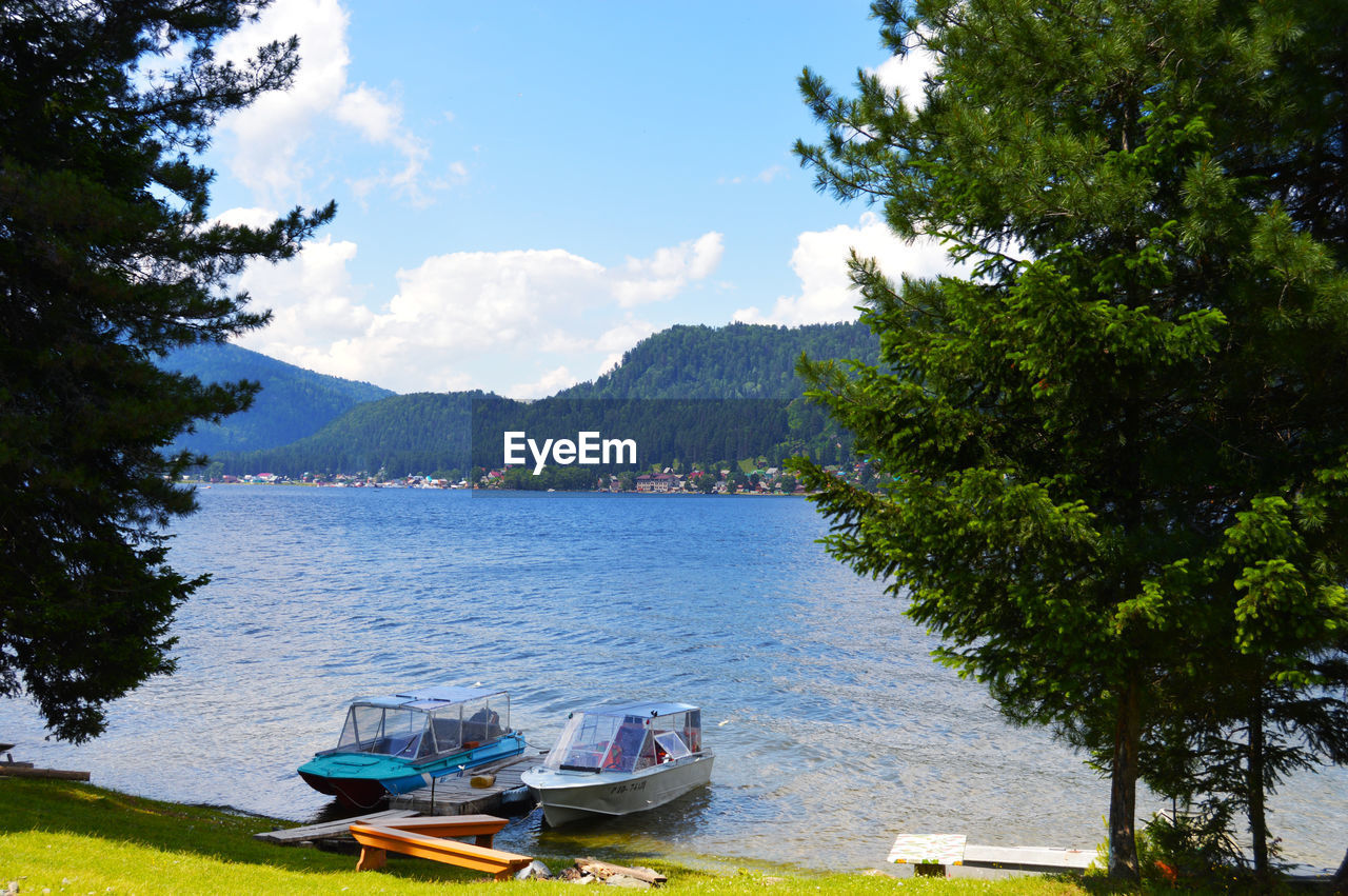 Boats moored in lake against sky