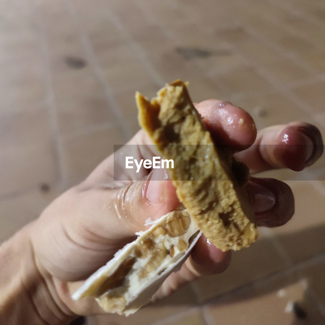 CLOSE-UP OF PERSON HAND HOLDING FOOD