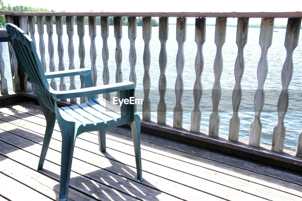 EMPTY CHAIRS AND TABLE AGAINST WALL OUTDOORS