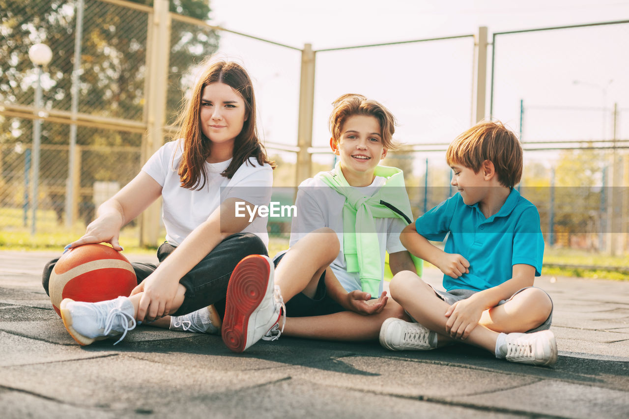 Portrait of teenagers sitting on a basketball court. children relax 