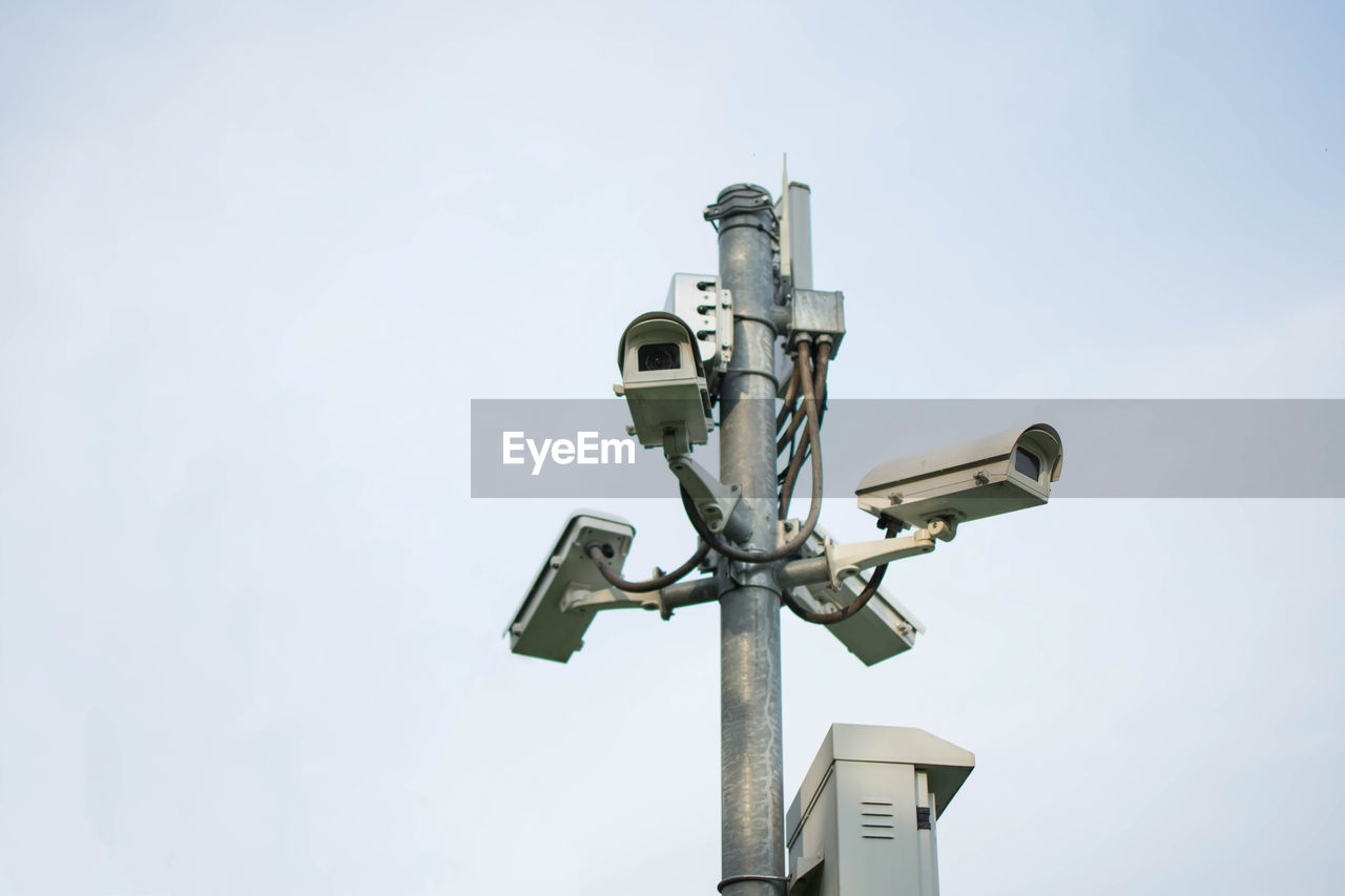 Low angle view of security cameras against clear sky