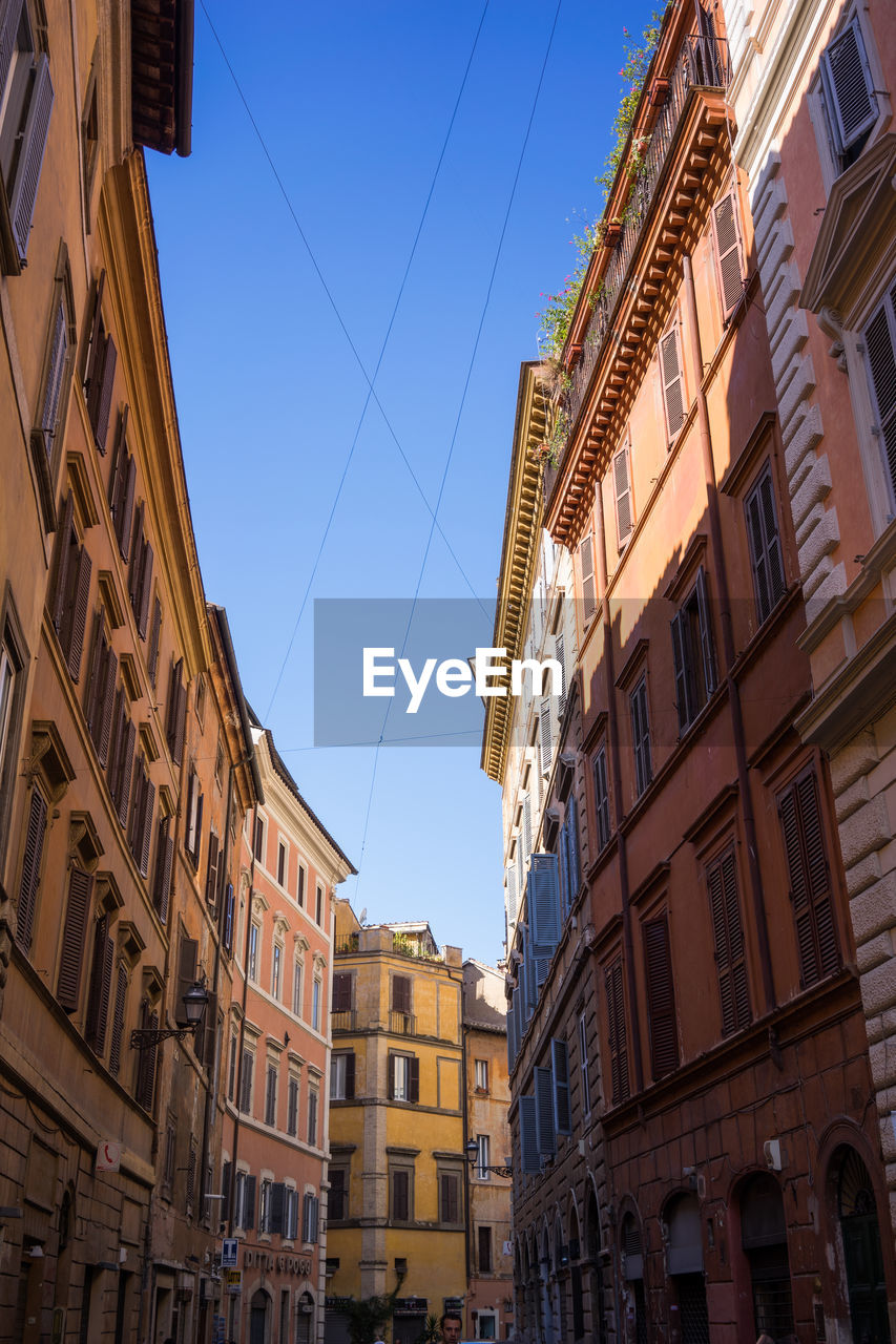 Low angle view of buildings against clear blue sky