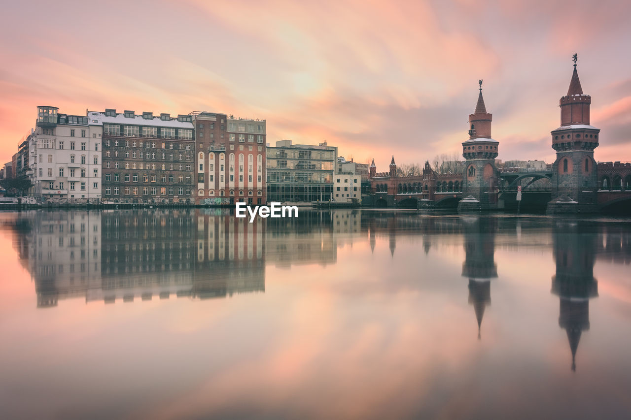 Reflection of buildings in water at sunset