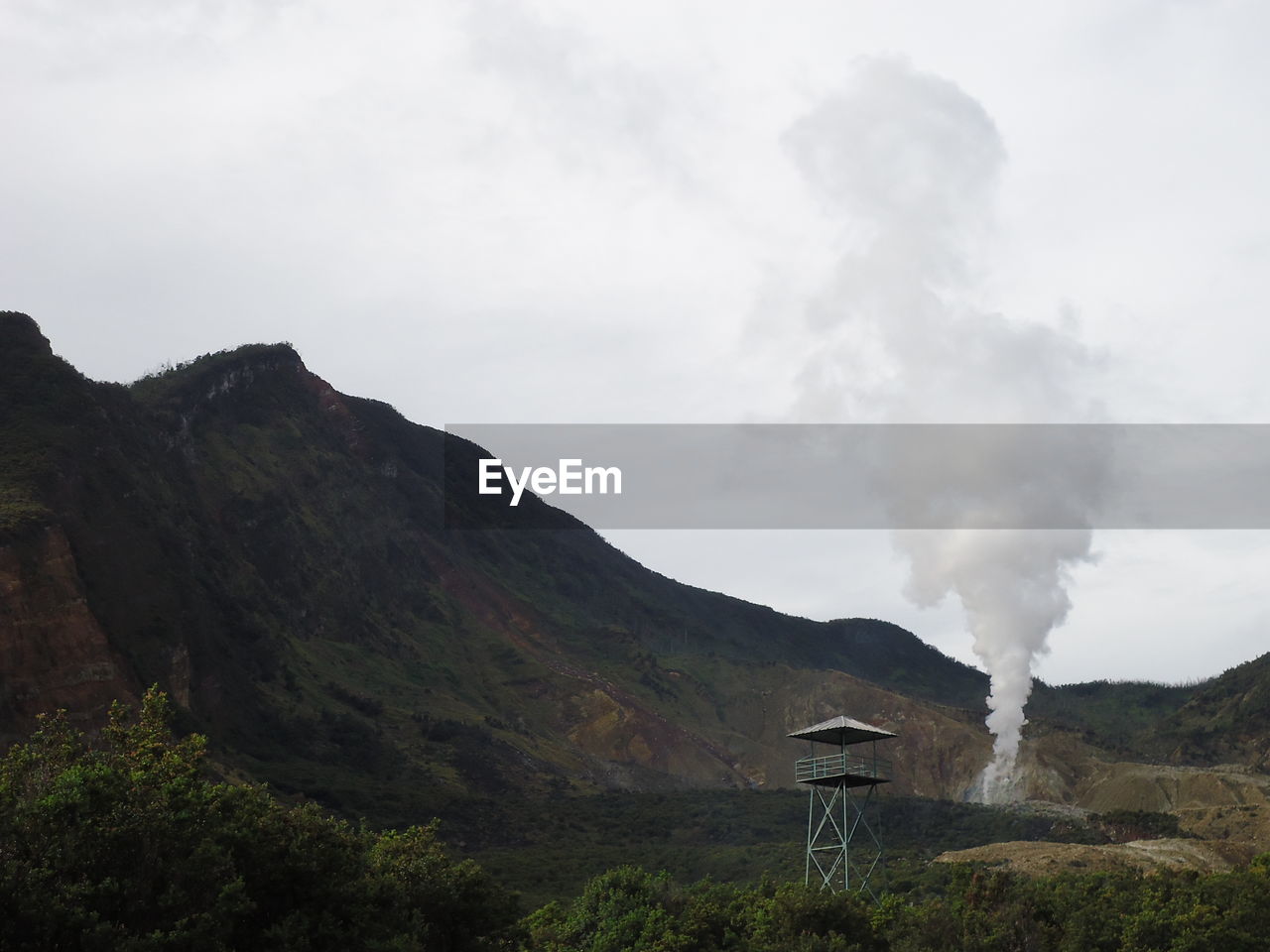 Smoke emitting from volcanic mountain against sky