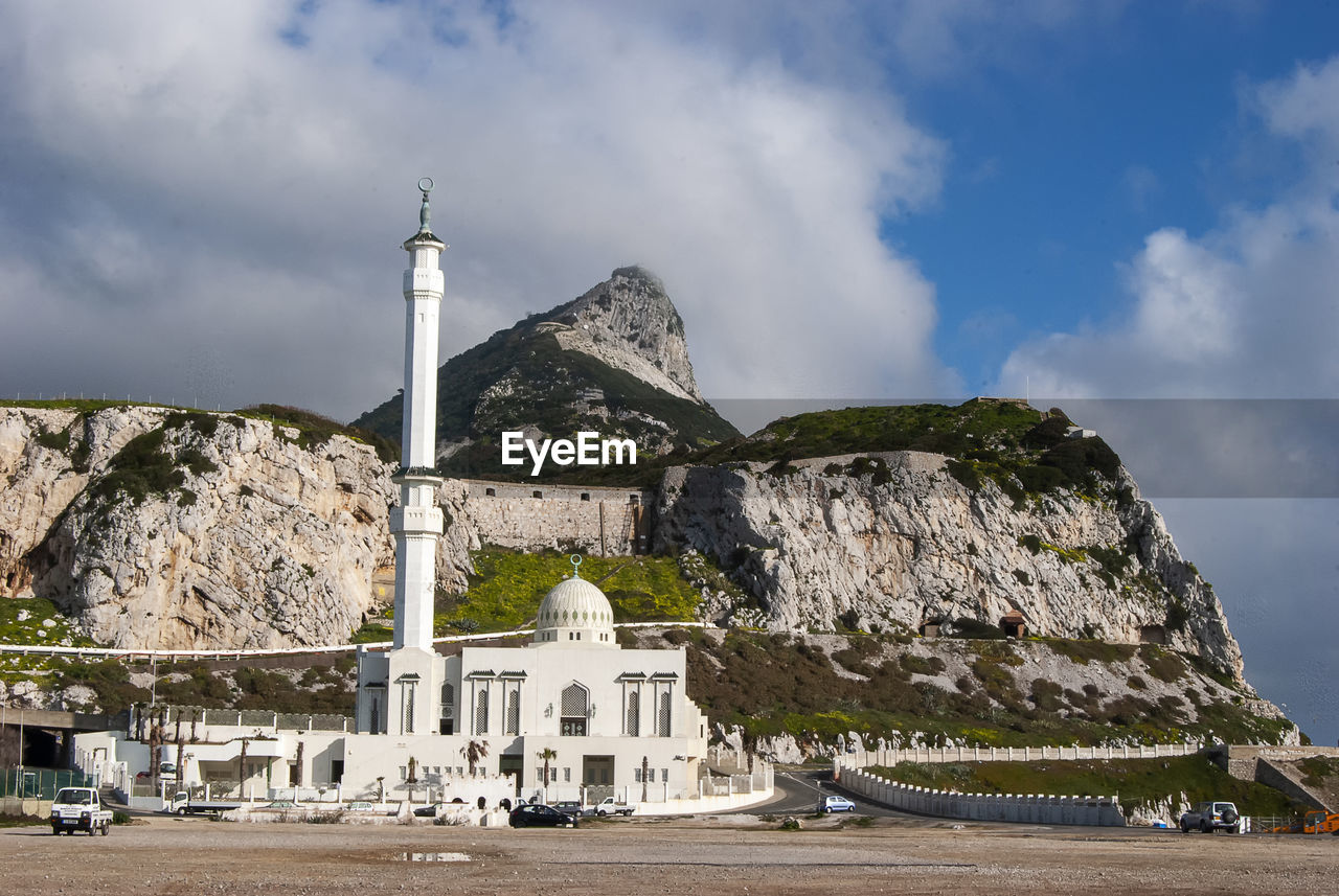 BUILT STRUCTURE BY ROCK AGAINST SKY AND MOUNTAIN