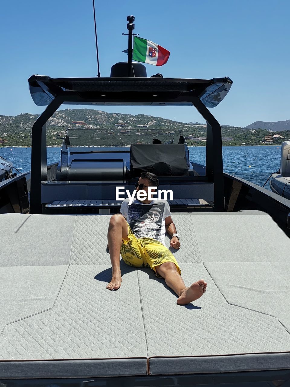 Full length of man sitting on yacht against sea