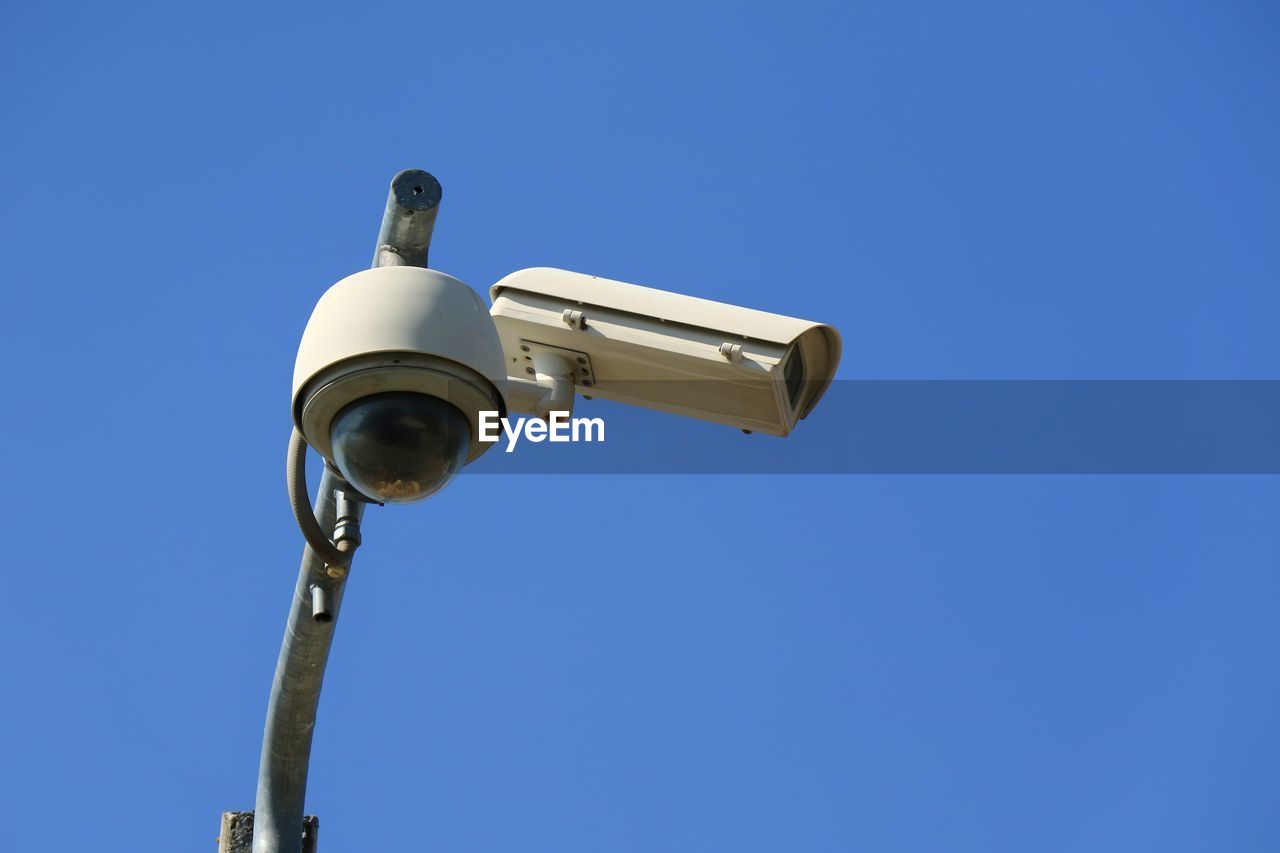 Cctv security camera at public street in the city with blue sky background.