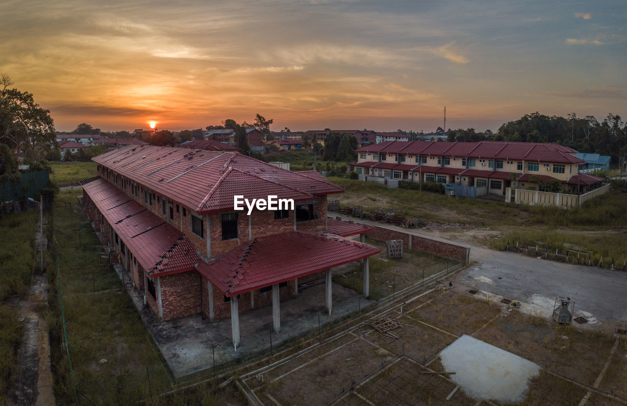 High angle view of buildings on land against sky during sunset