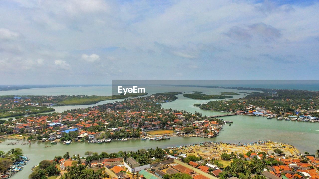 High angle view of townscape by sea against sky